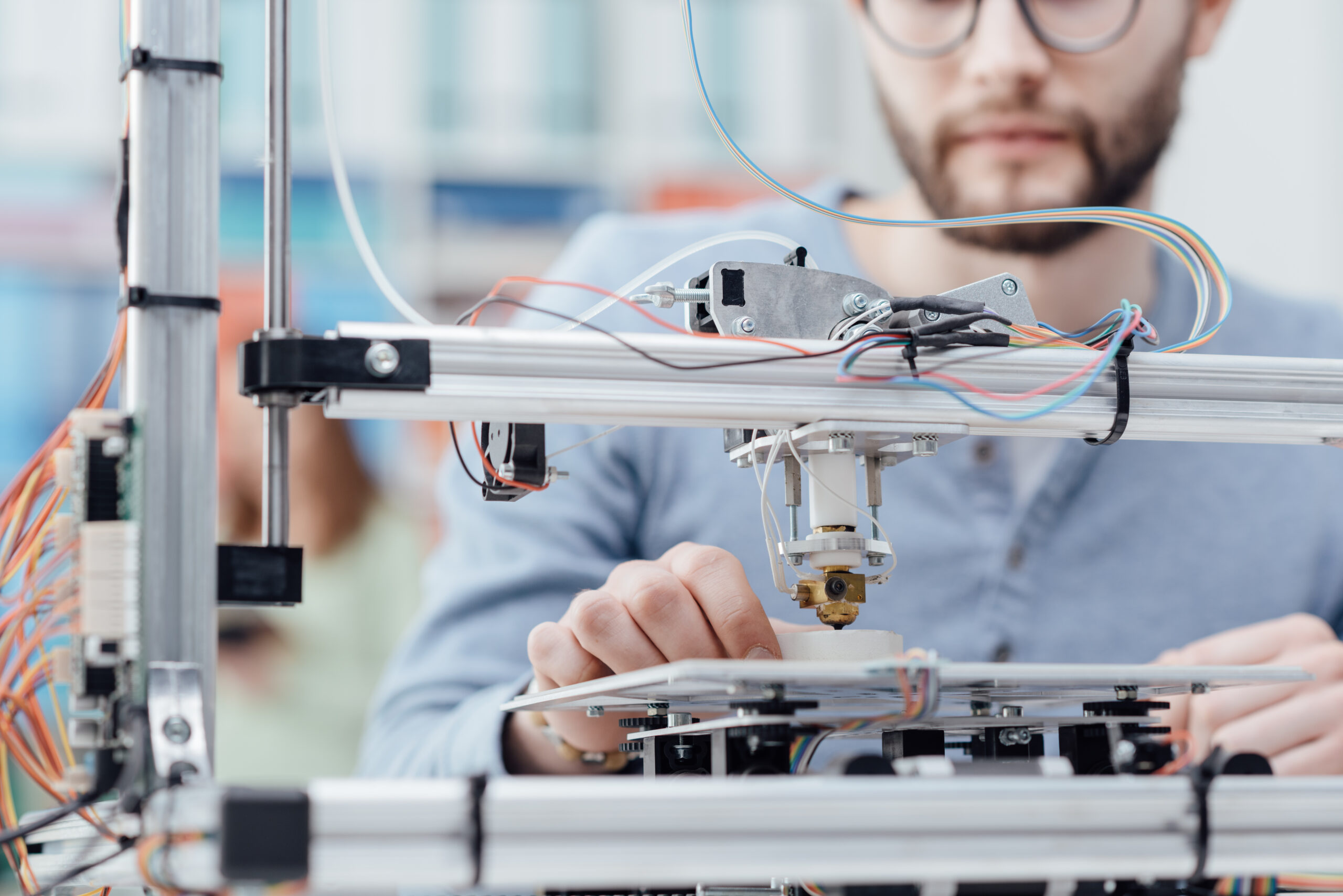 Engineering student using a 3D printer in the lab and printing a prototype